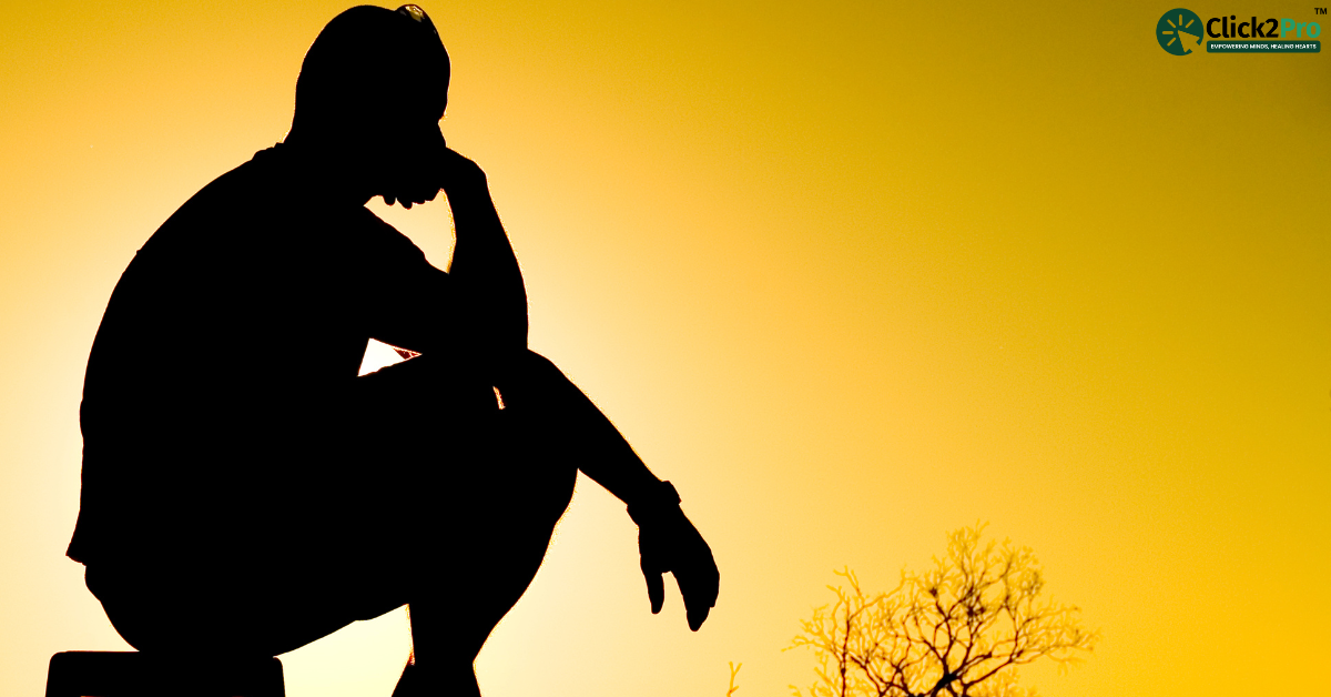 Silhouette of a person in deep thought against a sunset sky, symbolizing hidden signs of depression.