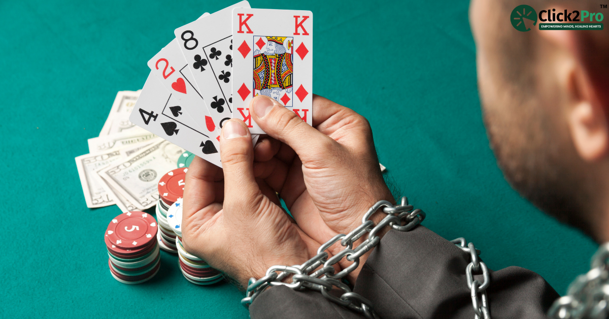 Person chained while holding playing cards, symbolizing gambling addiction and the struggle to break free.