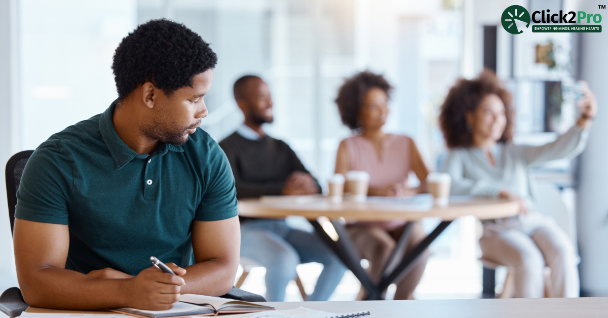 Man sitting apart, appearing disengaged from group, highlighting antisocial personality disorder impacts.