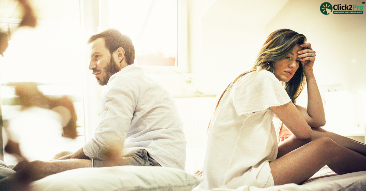 Couple experiencing emotional distance and loneliness in their relationship, sitting apart on bed