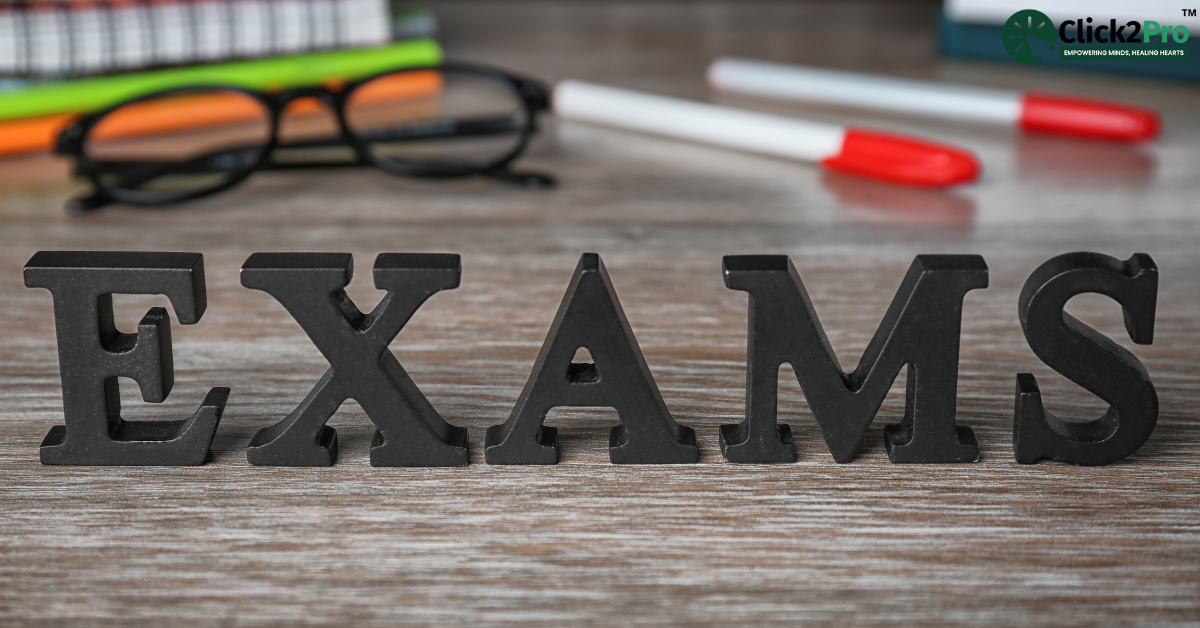 EXAMS text block with study materials on a desk, representing academic stress and exam anxiety.