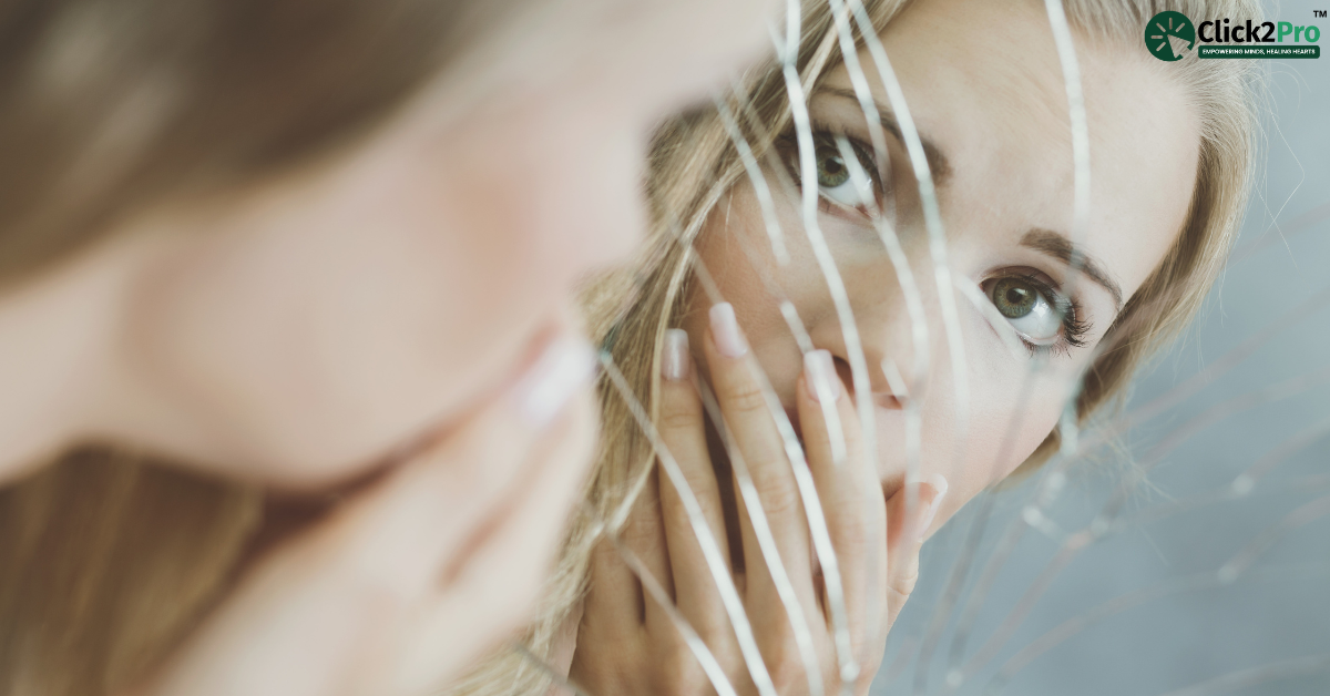 Reflective woman with hands covering mouth looking into a cracked mirror, symbolizing mental health struggles.