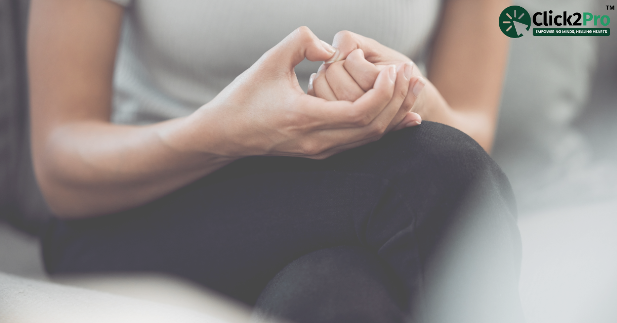 Person displaying anxious body language by nervously clasping hands, indicating mental health indicators.