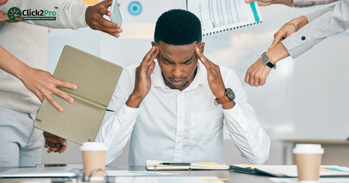 Stressed employee at a desk surrounded by work demands - managing workplace stress strategies